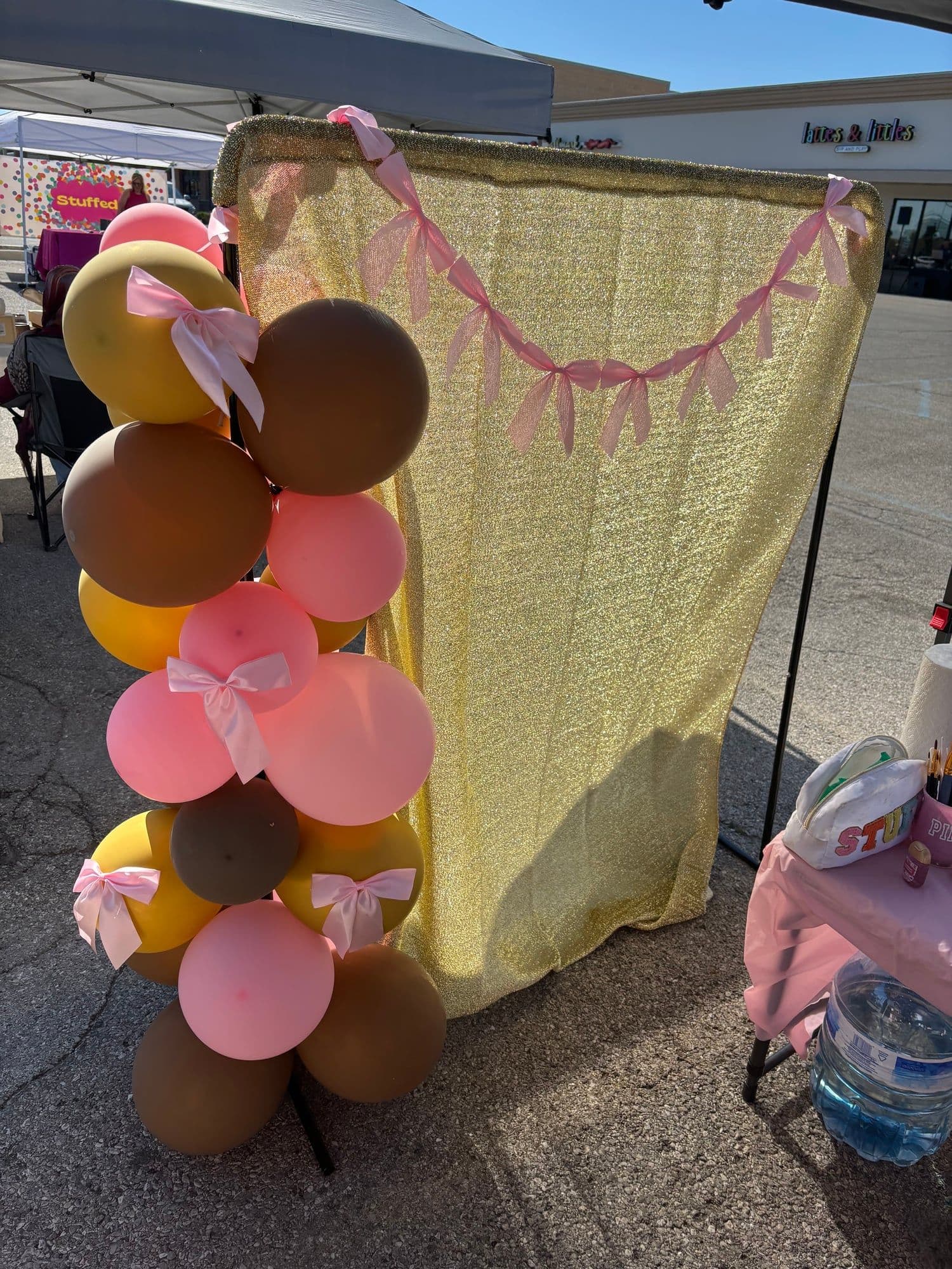 Pink, gold, and mocha balloon garland with pink bows and a gold sequin backdrop by MollyBoo Events